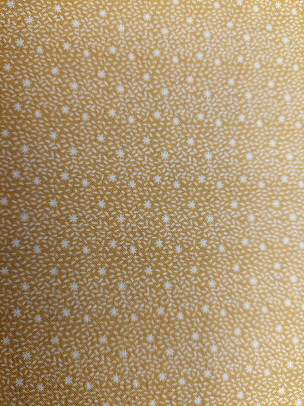 Baumwoll-Popeline mit weißen Sternchen auf senffarbigem Hintergrund