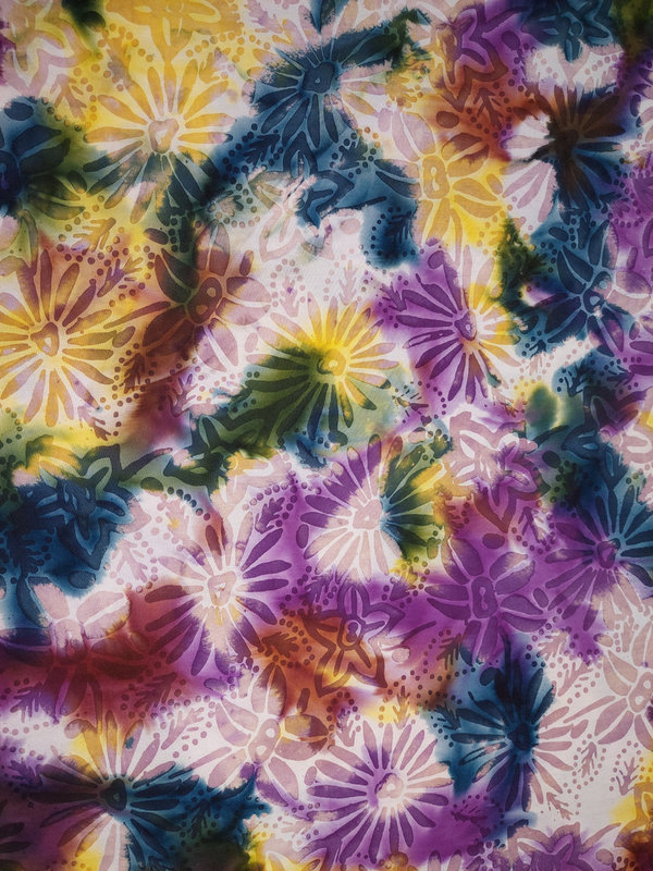 Baumwollstoff mit lila-gelbem Blumenmuster in Batik-Optik