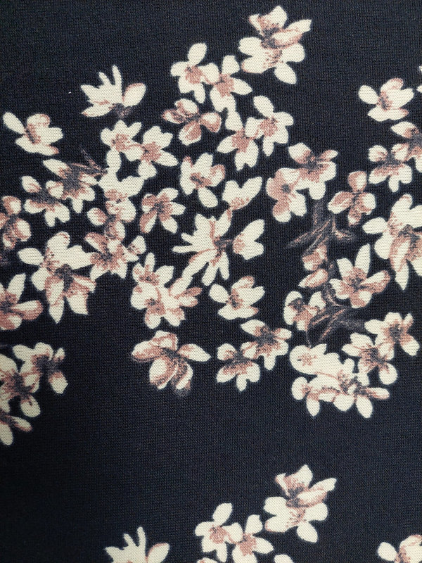 Feinstrick mit weißen und altrosa Blüten auf dunkelblauem Hintergrund